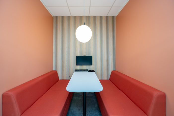 Meeting pod with orange banquette seating