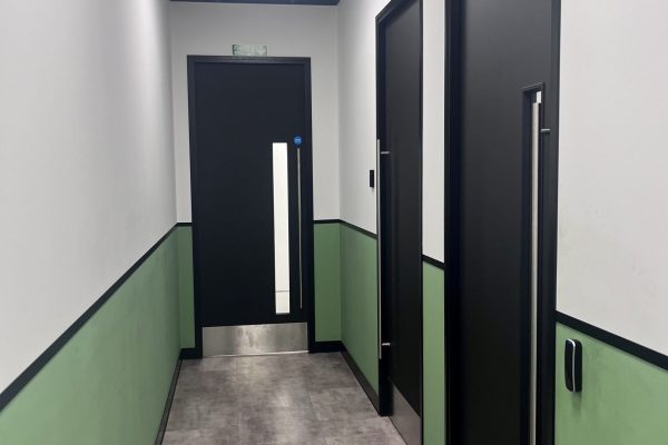 Green and white office Corridor with black laminate doors